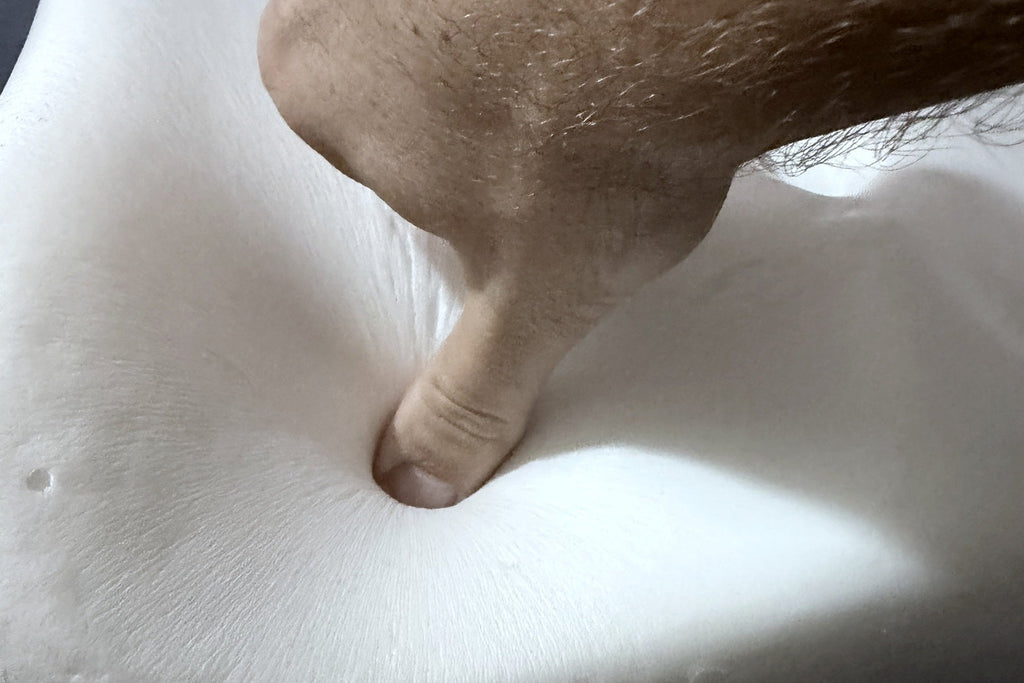 Pouce enfoncé dans la mousse à mémoire de forme nue du coussin d'assise Mirlune